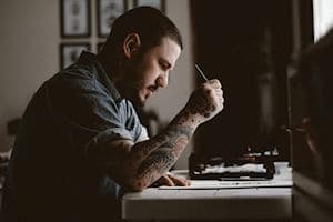 Tatuador sentado dibujando